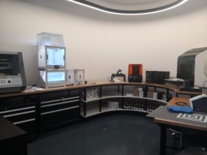 room with rounded walls and benches housing 3D printers, a CNC milling machine, a braille embosser and more