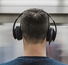 head and shoulders of man wearing headphones, seen from behind