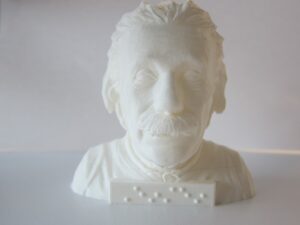 Head and shoulders of Albert Einstein with name in braille at front